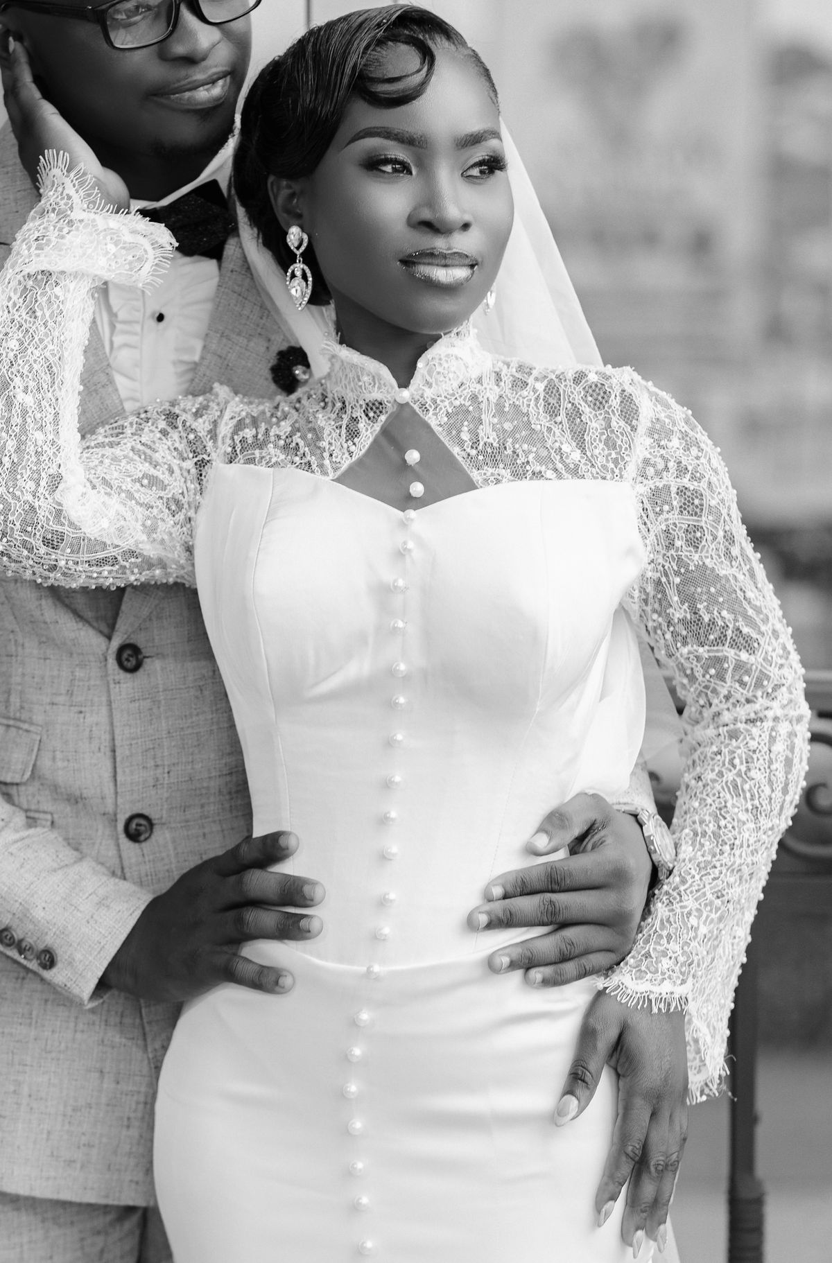 Black bride and groom embracing in wedding attire